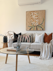 This image shows a professionally styled living room as part of a home staging Melbourne project by Elevate Your Space, featuring modern furniture, neutral tones, and balanced styling designed to attract buyers and enhance property appeal.